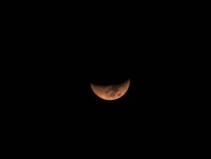 reddish partial lunar eclipse night sky